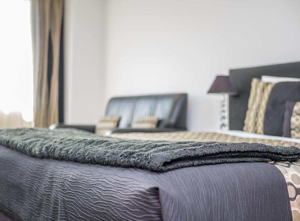 Bellano Motel Suites Christchurch Esterno foto A bed with a throw